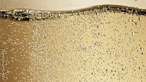 Fototapeta Close-up of champagne bubbles background with foam.
