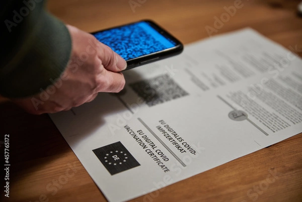 Fototapeta Person scanning the QR code of a covid 19 certificate. Scanning the coronavirus green pass.