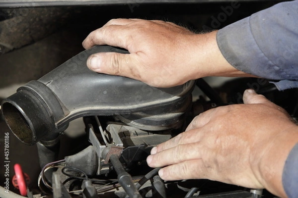 Fototapeta Old car engine air filter check - service man hands holding the air filter box on mono injector fuel system unit closeup, motor repair service