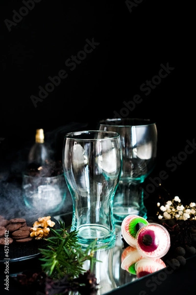 Obraz An eerie Halloween-themed cup, made of transparent glass, against a haunting black backdrop. Halloween glass cup.