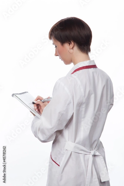 Fototapeta Молодая девушка делает запись в тетрадь