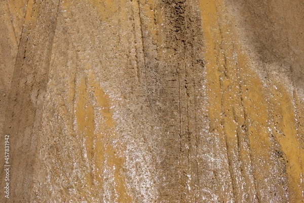 Obraz Traces de pneus sur une route boueuse en terre humide de couleur rouille