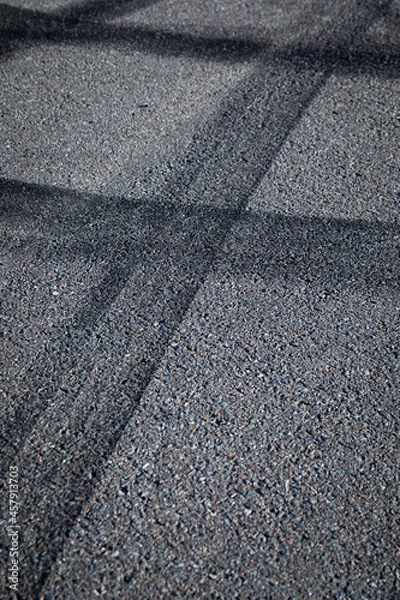 Fototapeta Abstract background with black tire tracks skid on asphalt road, vertical format, no person