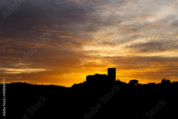 Obraz Silhouette of the village and castle of Mértola at sunset, Portugal. Amazing sunset with clouds giving texture to the photo. Alentejo.