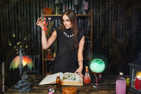 Obraz Young beautiful witch preparing a potion for Halloween 