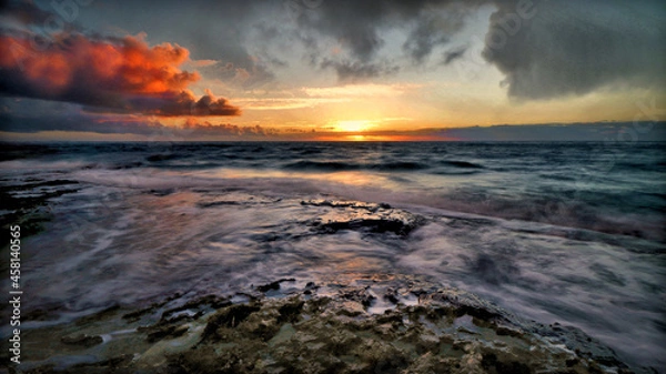 Fototapeta Sun Rising over the sea and the horizon displaying the color and beauty in the sky. The 