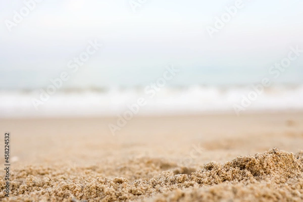 Fototapeta Close up sand with blurred sea sky background, summer day, copy space or for product