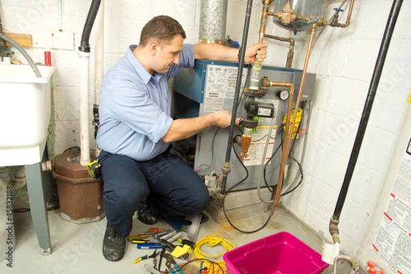 Obraz Plumber repairs furnace