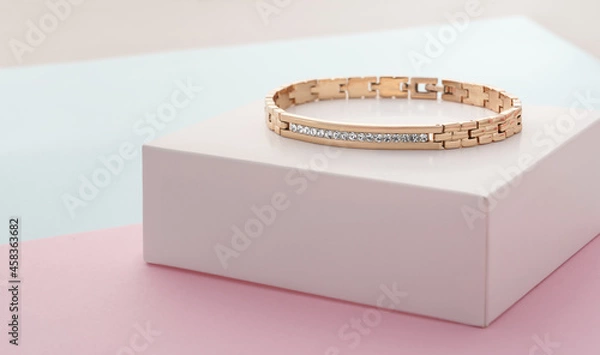 Fototapeta Focus on diamonds on golden bracelet on pastel colors background with copy space