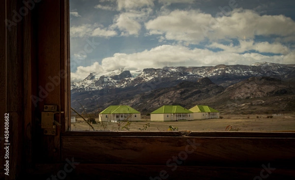 Fototapeta Houses in the middle of the mountains seen through the window