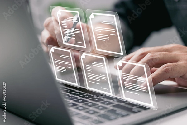 Obraz Businessman working on laptop computer with electronics document icons, E-document management, online documentation database, paperless office concept