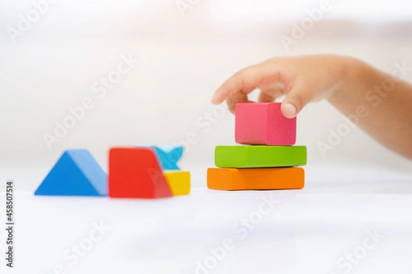 Fototapeta Close up Children hand Practice the skills of playing with wooden toys on the table in living room. Asian little boy education from home. Developing children's learning before entering kindergarten