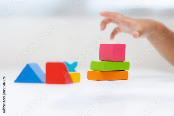 Fototapeta Close up Children hand Practice the skills of playing with wooden toys on the table in living room. Asian little boy education from home. Developing children's learning before entering kindergarten