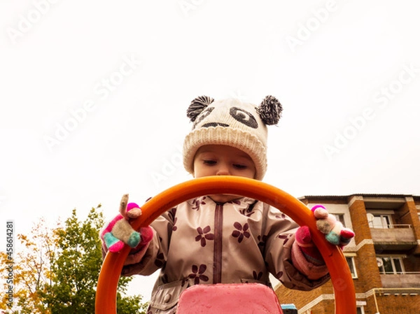 Fototapeta cute and funny baby playing on the playground on an autumn day