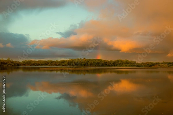 Fototapeta bright rainbow on the background of beautiful pink clouds floating at sunset on a summer evening