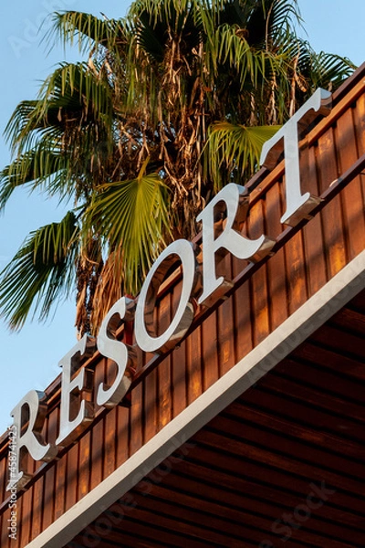 Fototapeta the inscription resort on the hotel building on a background of palm trees