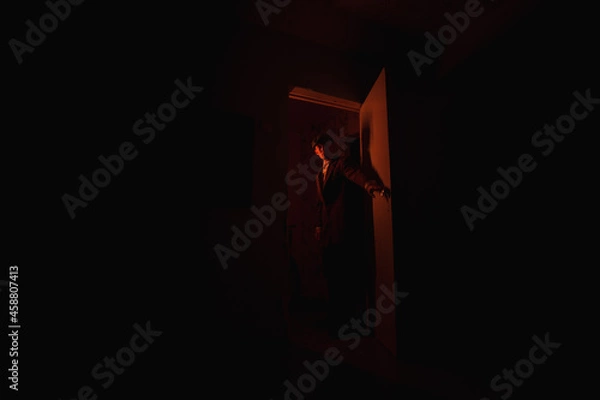 Obraz man in a doorway in the dark.