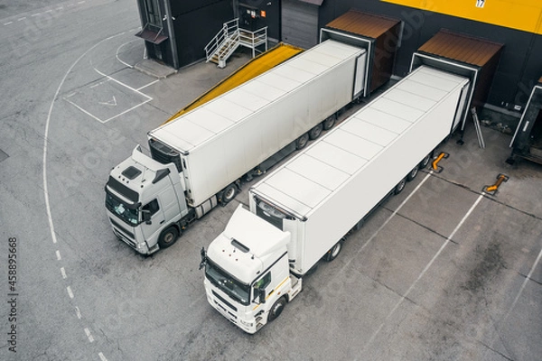 Fototapeta Two trucks loading in the distribution hub