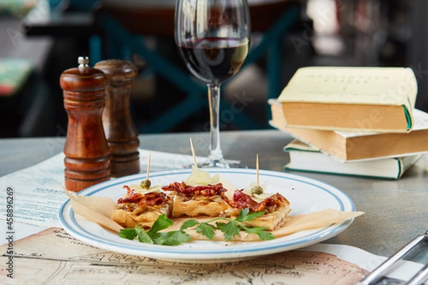 Obraz bruschetta on a wooden table in a white plate and a glass of red wine