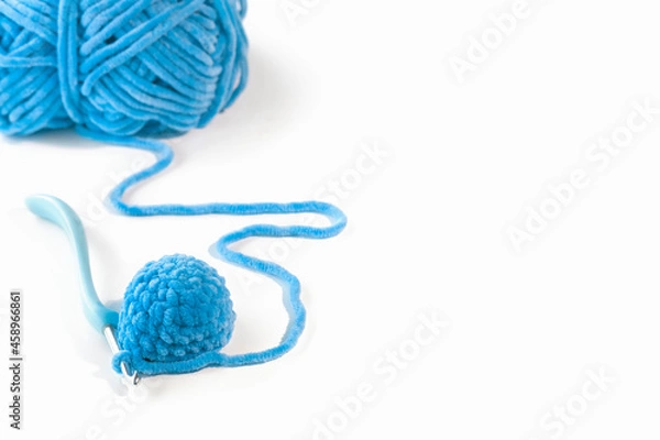 Obraz Needlework crochet with a skein of blue yarn on a white background