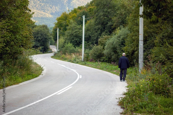 Fototapeta Happy senior man walking on the road line