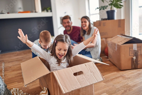 Obraz A young family is playing in the new home they have just moved in. Home, family, moving