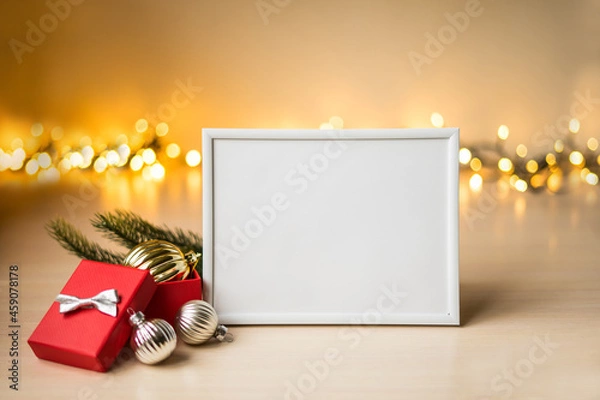 Fototapeta Portrait white picture frame mockup on table with boken lights and christmas decoration