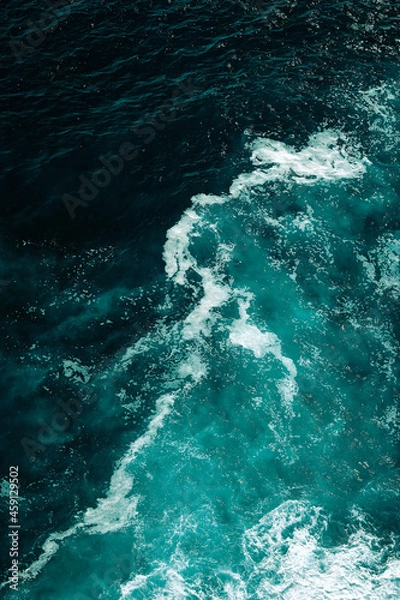 Fototapeta Aerial view to seething waves with foam. Waves of the sea meet each other during high tide and low tide