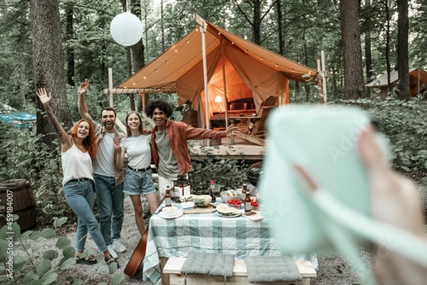 Fototapeta Photographer view of making polaroid photo of friends on picnic, camping glamping life, resting with diverse friends outdoors, enjoying summer camping trip, having fun time in forest, copy space