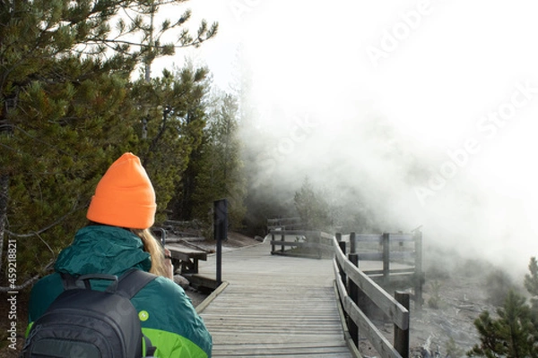 Fototapeta Girl in the clouds on a boardwalk. Adventures and exploration perfect for social media.