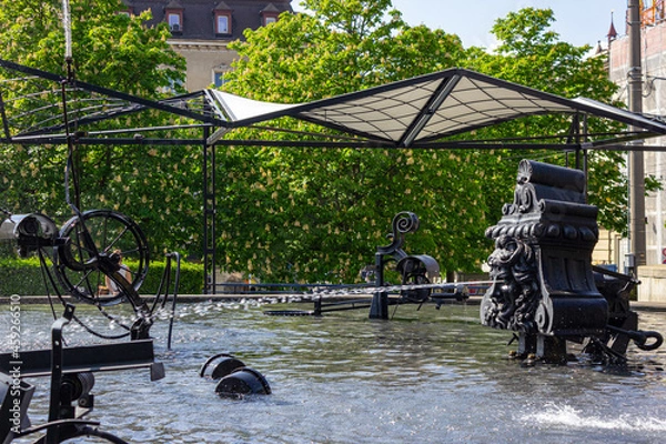 Fototapeta Playful trick fountains at Fasnachtsbrunnen (carnival fountain), also called Tinguely Brunnen (Tinguely fountain), in Theaterstrasse (theatre street) in Basel, Switzerland, on a beautiful sunny day