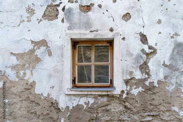 Fototapeta Small window in very old medieval and dilapidated building.