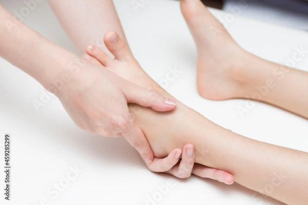 Obraz The masseur performs a foot massage for the girl. Orthopedics. Valgus and flat feet.