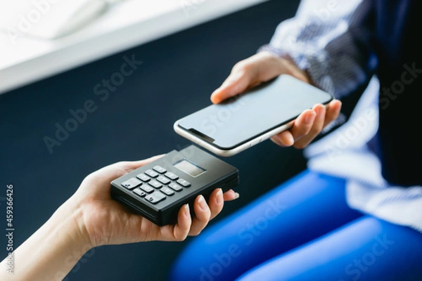 Fototapeta スマホ決済をする女性（手元・ボディパーツ・アップ）