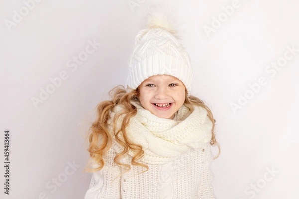 Fototapeta happy baby girl in warm hat and sweater on white isolated background, space for text