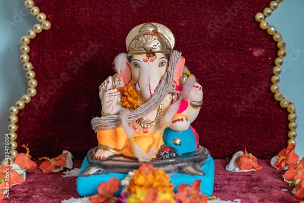 Fototapeta Idol of Lord Ganesh of a shadu clay a Hindu Religion God on the occasion of 'ganesh chaturthi' in India with flowers and decoration.