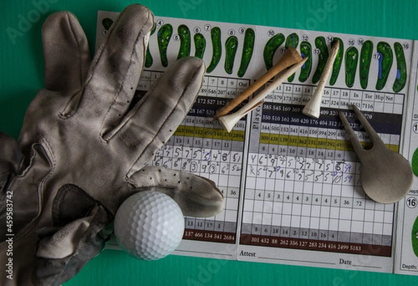 Obraz Golf score card of a mess of a game with tee's, torn golve and tools, close-up,