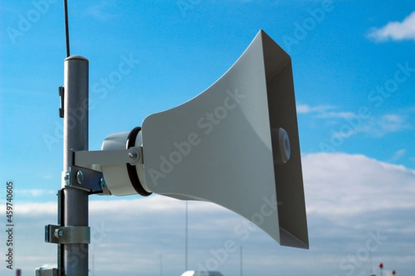 Fototapeta Loudspeaker of the emergency warning system against the background of a blue sky.