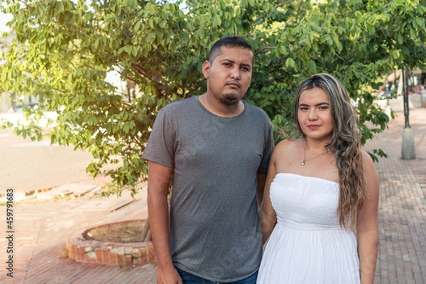 Fototapeta Portrait Of A Hispanic Couple In Front Of A Tree Outdoors.
