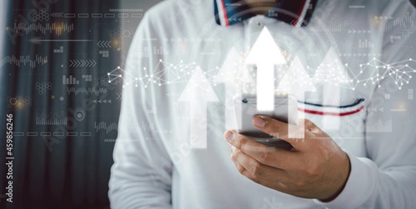 Fototapeta Businessman using mobile phone for business development of success and growth up concept. Point rising arrow graph corporate future level up plan. Successful investment decision. Management  goal.