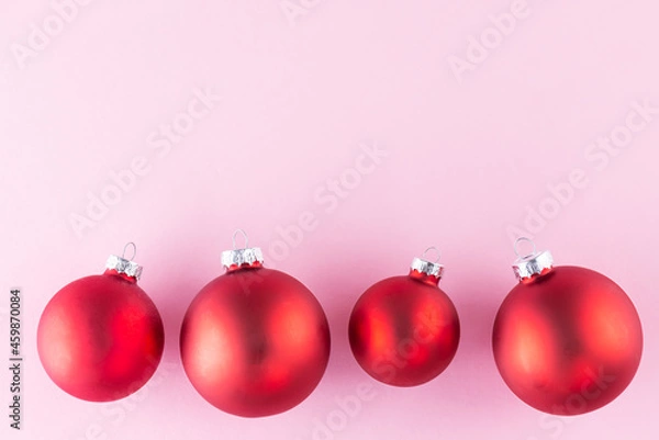 Fototapeta Red Christmas balls on a pink background. Christmas and New Year concept. Horizontal orientation, copy space, top view.
