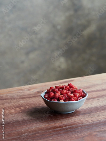 Fototapeta fresh wild strawberries in a small bowl on a wooden table. fragaria vesca