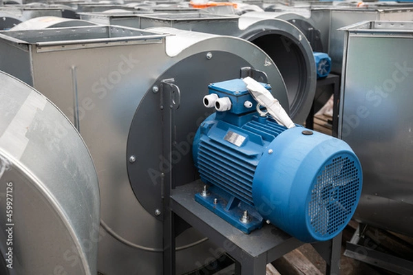 Fototapeta Batch of industrial exhaust snail fans with installed electric motors for air ventilation in a factory open-air warehouse storage area awaiting transportation.