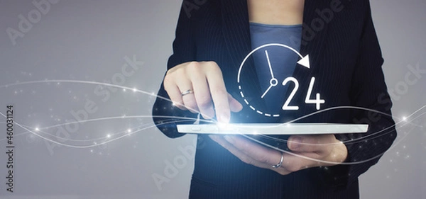Fototapeta Business button 24 hours service. White tablet in businesswoman hand with digital hologram 24/7 all day all night icon on grey background. Full time service concept