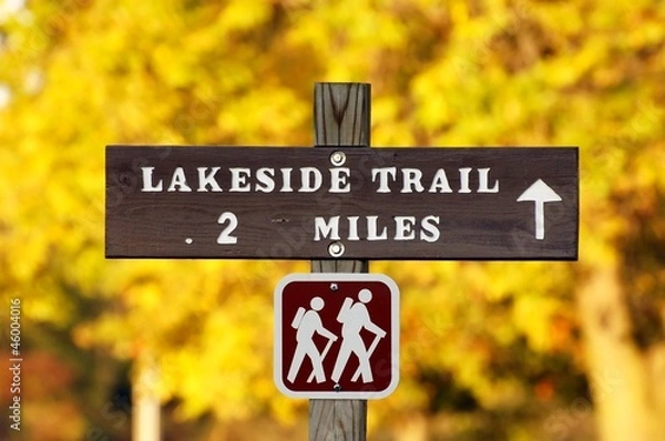 Fototapeta Hiking trail sign with yellow autumn foliage