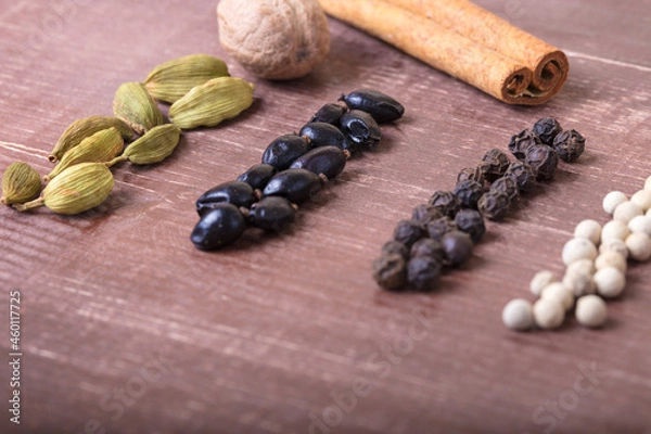 Obraz Cardamom, nutmeg, cinnamon and other aromatic spices lie on a wooden table
