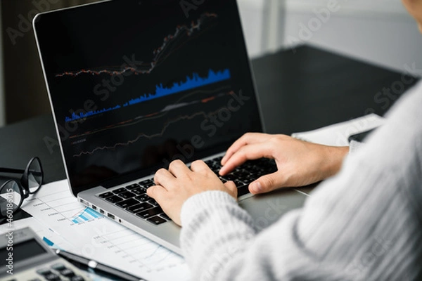 Fototapeta Close up of investor women using laptop computer trading stock market via apps online at home, indicator analysis index chart graph trend line, investment and financial business concept.