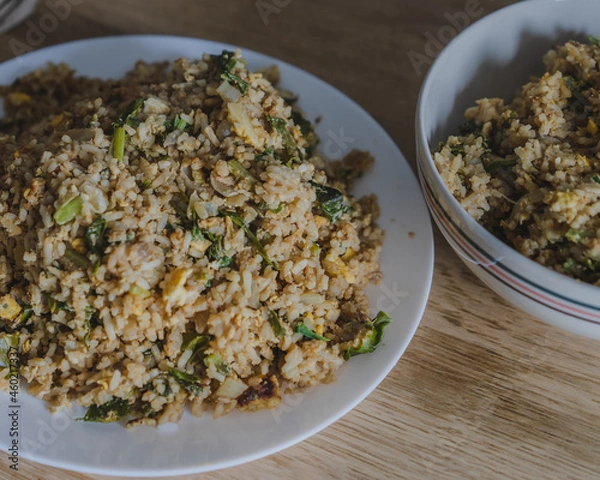 Obraz Stir fried rice with chicken ,kale ,onion, egg in a white plate on the wood table for cooking.