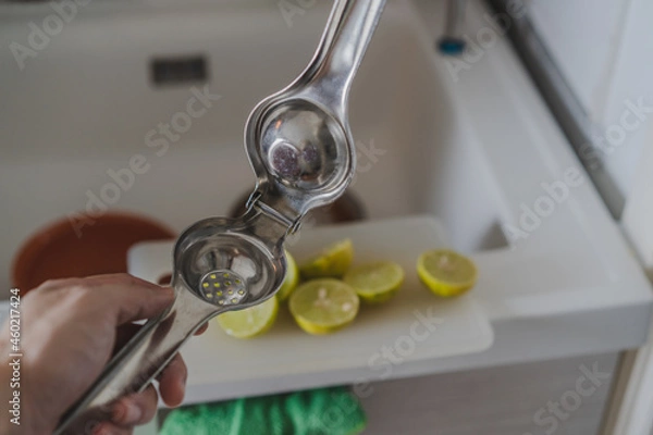 Obraz Lemon queezer stainless with lemon sliced on cutting board background for cooking.