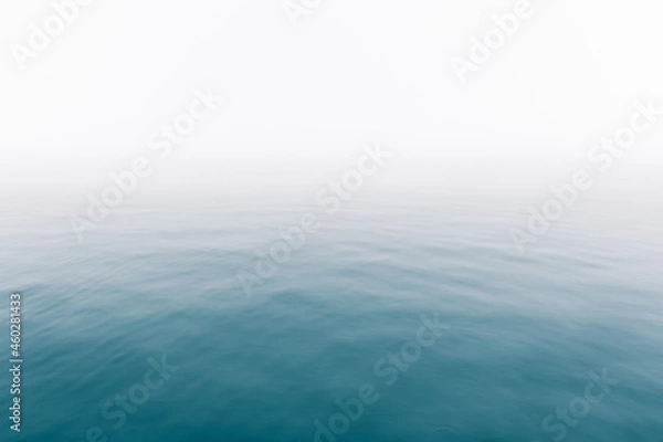 Fototapeta Heavy fog over calm ocean water surface - soft misty scenery on the sea with subtle ripples - Infinity - Calmness - serenity - lonely - quiet - moody background copy space